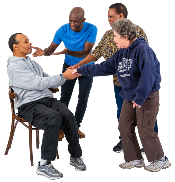 A picture of a man seated with 3 people visting him